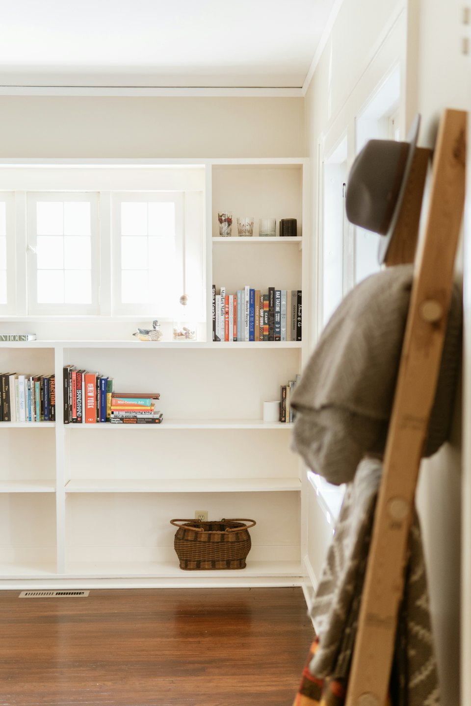 White shelves filled with books and decor in a bright room.