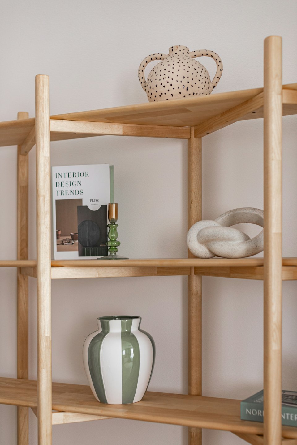 Modern wooden bookshelf filled with books and decorative home objects.